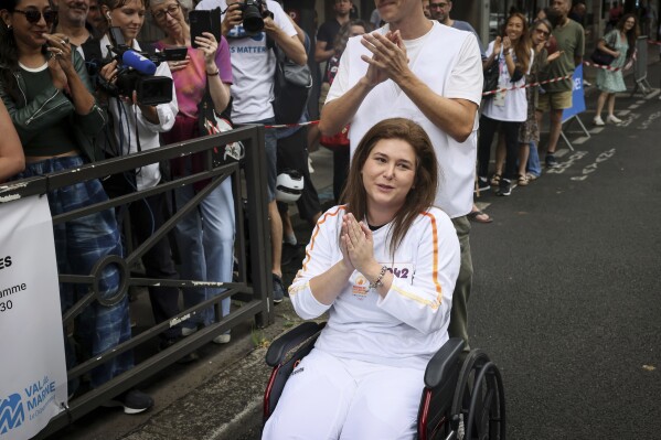 A Lebanese photojournalist, wounded in Israeli strike, carries Olympic torch to honor journalists